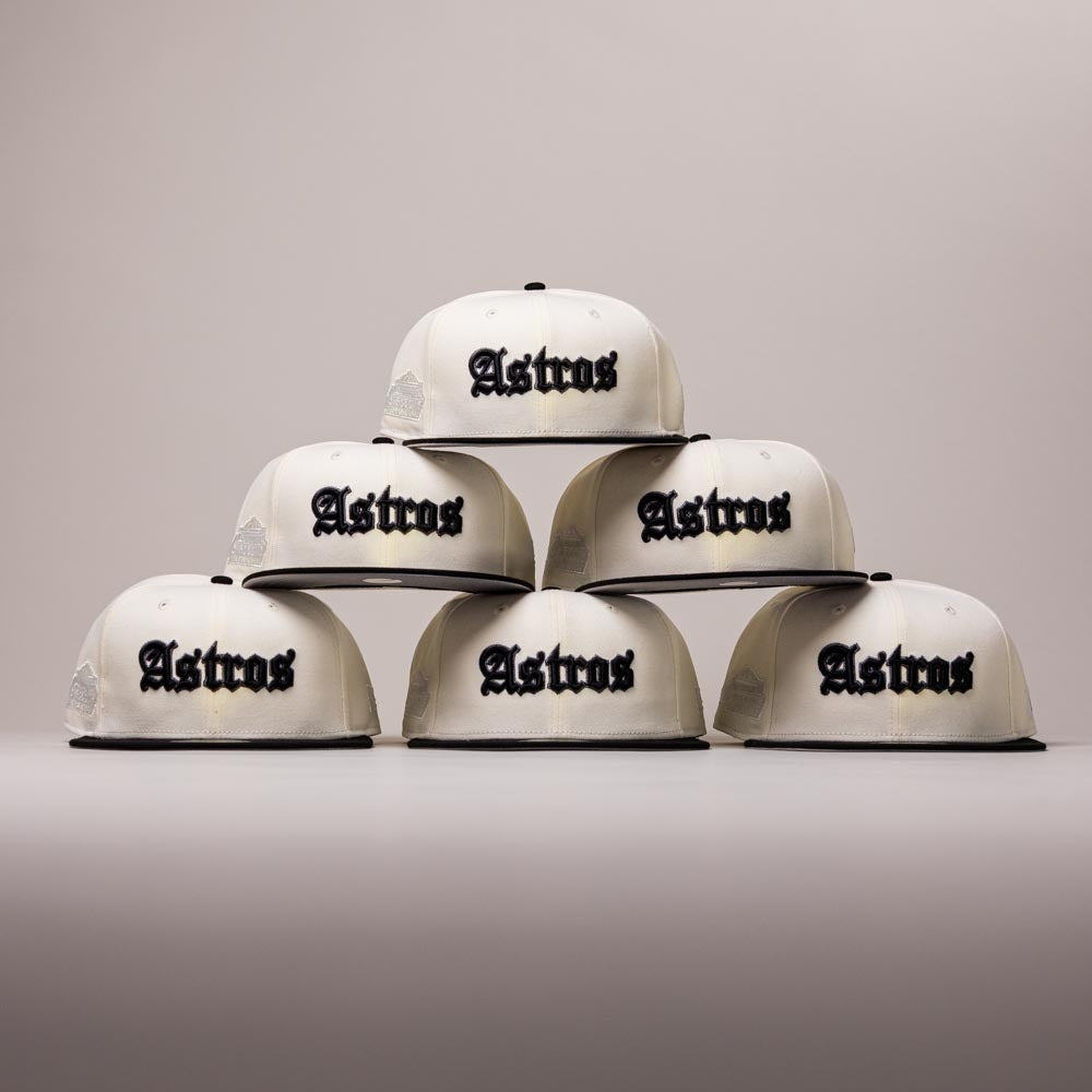 Six Straight Outta Southside OG Chrome Black Houston Astros New Era 5950 Fitted hats, each featuring the team name in bold black letters, are stacked in a pyramid shape against a plain, light background—a striking tribute to the Houston Astros and classic New Era hat style.