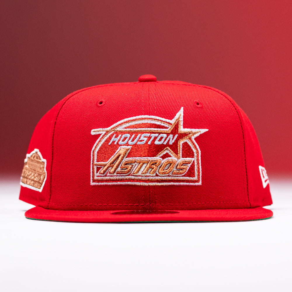The H Town South Houston Astros New Era Hat 5950 Fitted is a red baseball cap featuring gold and white embroidery of the team logo on the front, a commemorative patch on the side, and a New Era logo on the opposite side; displayed against a red gradient background.
