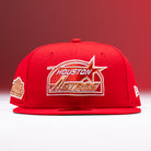 The H Town South Houston Astros New Era Hat 5950 Fitted is a red baseball cap featuring gold and white embroidery of the team logo on the front, a commemorative patch on the side, and a New Era logo on the opposite side; displayed against a red gradient background.