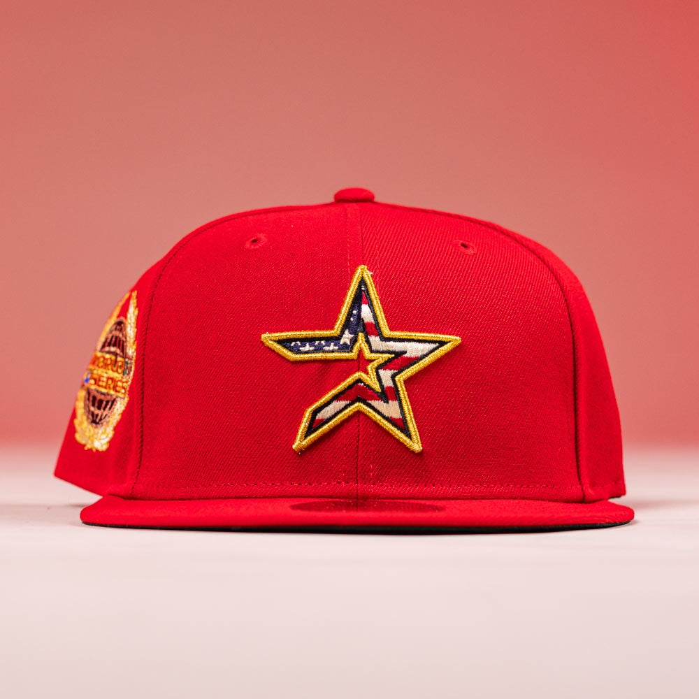 The Crest Lo 2.0 Houston Astros New Era Hat 5950 Fitted is a red fitted cap with a large star patch in an American flag design on the front, a circular embroidered side patch, and subtle Houston Astros accents against a red background.