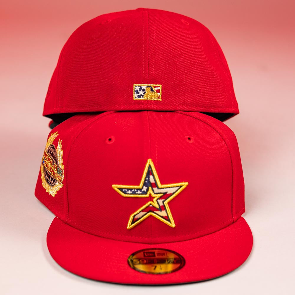 Two red Crest Lo 2.0 Houston Astros New Era 5950 fitted hats: one has a large gold-outlined Astros star with an American flag pattern and a gold/red side patch; the other features a small flag patch on the back, both on a pink gradient background.