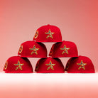 Six Crest Lo 2.0 Houston Astros New Era 5950 Fitted hats are arranged in a pyramid. Each has a yellow-bordered star patch on the front and a side Astros logo, displayed against a reddish-pink background with lighting.