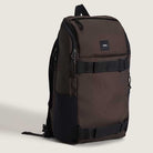 The Obstacle Skatepack Backpack (VN0A3I69OVB1) in brown ripstop by Vans Skateboarding features black straps, a front pocket, side mesh pockets, a small upper-front Vans logo patch, and a laptop compartment, shown upright on a plain light background.