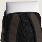 A silver laptop partially tucked into the laptop compartment of an Obstacle Skatepack Backpack VN0A3I69OVB1 Brown Ripstop by Vans Skateboarding with padded mesh straps.