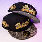 Two Oil Spill WS05 Houston Astros New Era 5950 Fitted hats in black with gold embroidered logos, world patches, patterned gray and black brims, and gold 5950 Fitted size stickers on the visors.
