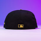 The Oil Spill WS05 Houston Astros 5950 Fitted New Era Hat in black, shown from the back with a gold MLB logo above the edge, is set against a purple gradient background.