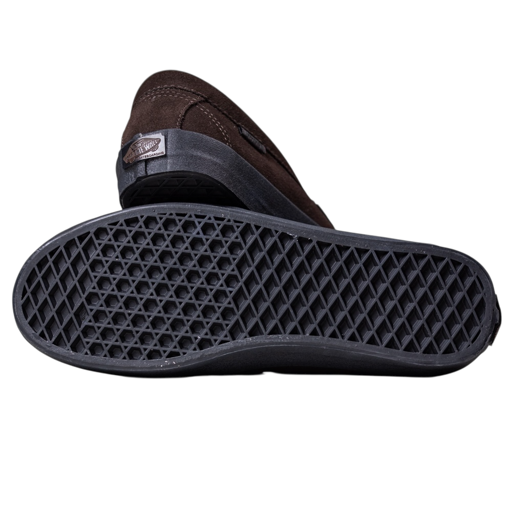 A pair of Skate Loafer Vans VN000VA6Y491 Brown Black Suede Skateboarding Shoes—one on its side, one revealing a black waffle-patterned sole—showcases the rubber tread for excellent grip.