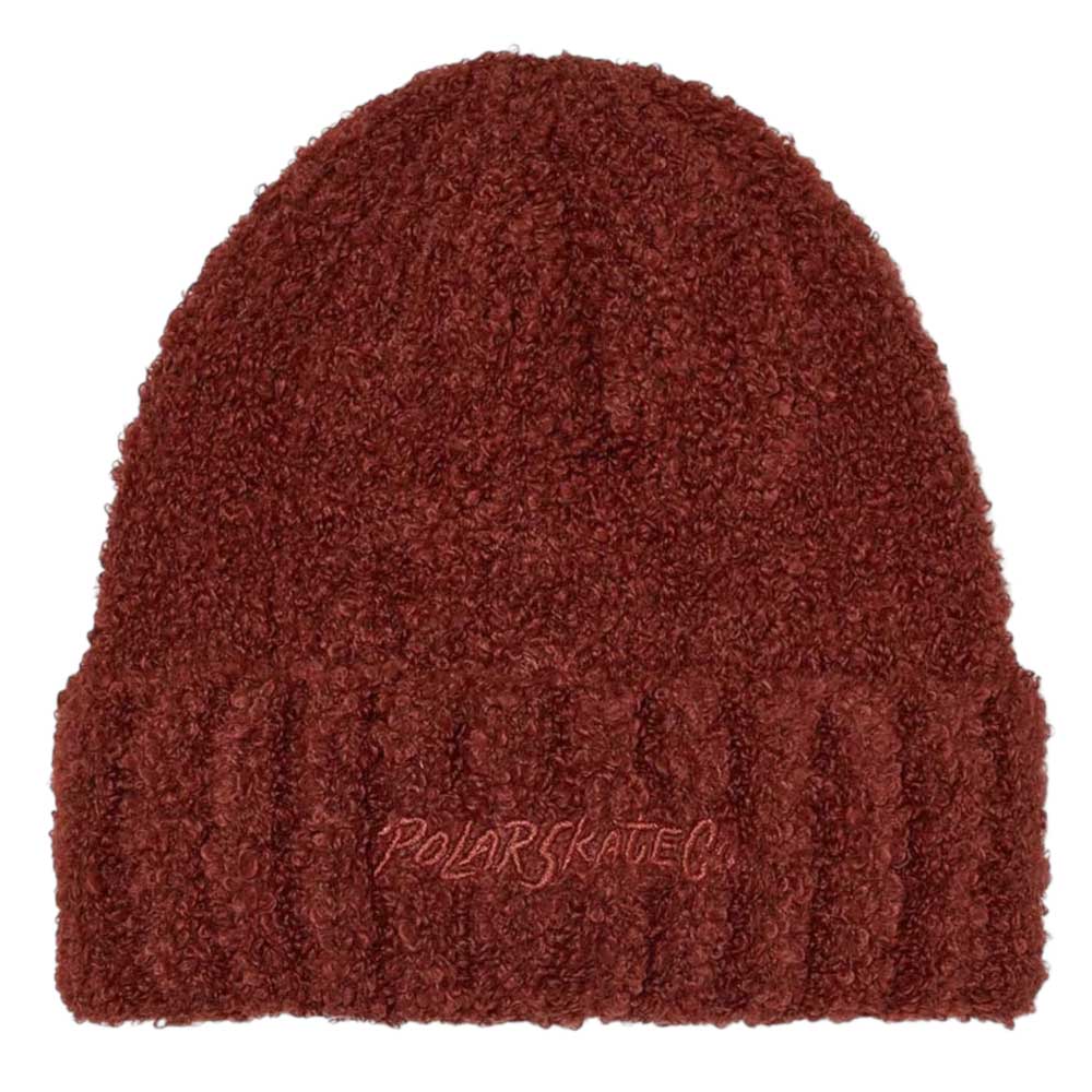 The Polar Beanie Fluff Rust is a textured dark red beanie made from cozy teddy yarn, featuring a ribbed folded brim and “POLAR SKATE CO” embroidered on the front for warmth and style.