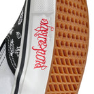 Close-up of the Punk and Yo x Vans Skate Slip On VN000EKPY281 Canvas Shoes, highlighting the sneaker’s waffle-patterned sole, “punkangelica” in red script along the side, and a portion of a black and white graphic on the upper—a tribute to skateboarding streetwear style.