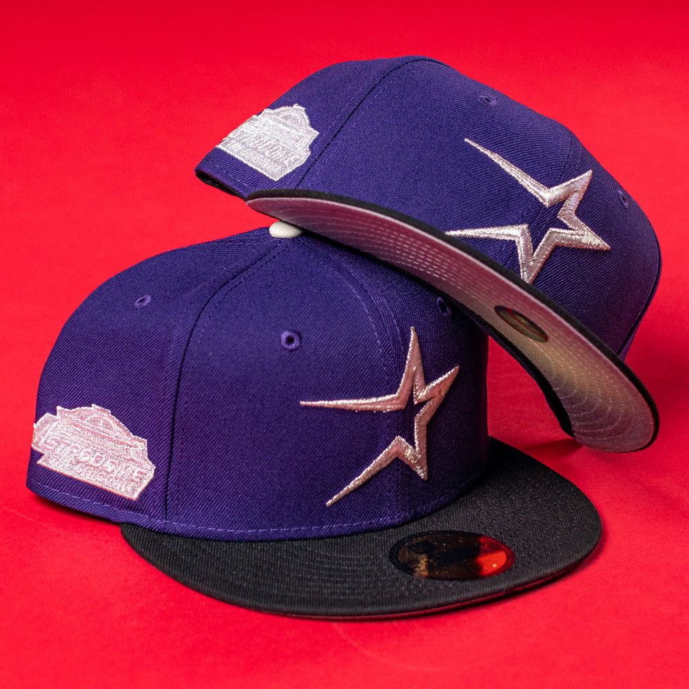 Two De Uva New Era Purple Houston Astros 5950 Fitted hats with black brims, silver star logos, and a commemorative patch are displayed on a red background—one upright, the other tilted BuryMeInTheSouf style.