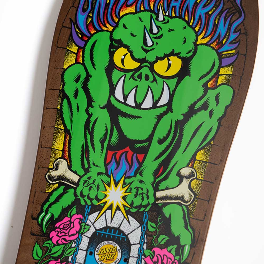 A colorful illustration of a green monster with yellow eyes and a horn, crouching on a gravestone with bones, roses, and blue chains, is featured on the Santa Cruz Rankine Monster Reissue 10.39in x 30.46in skateboard deck with classic Cruz Missile II concave.