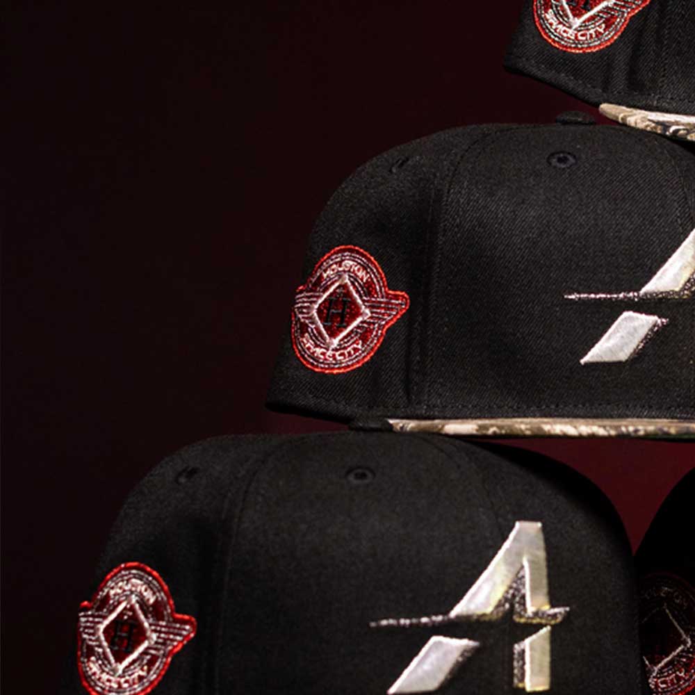 A close-up of three Pre-Order Red Dot Red City Connect Houston Astros New Era Hat 5950 Fitted caps with shiny silver A logos and red side emblems, stacked on a dark background. Enjoy convenient shipping options for your order.