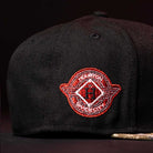 A close-up of the Pre-Order Red Dot Red City Connect Houston Astros New Era Hat 5950 Fitted, featuring a black cap with a red and white embroidered Space City logo and stylized H. Pre-order now with convenient in-store pick-up options.