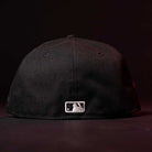 A Red Dot Red City Connect Houston Astros New Era 5950 Fitted Hat is shown from the back, featuring the MLB logo. Now available for pre-order with in-store pick-up options. The background is dark.