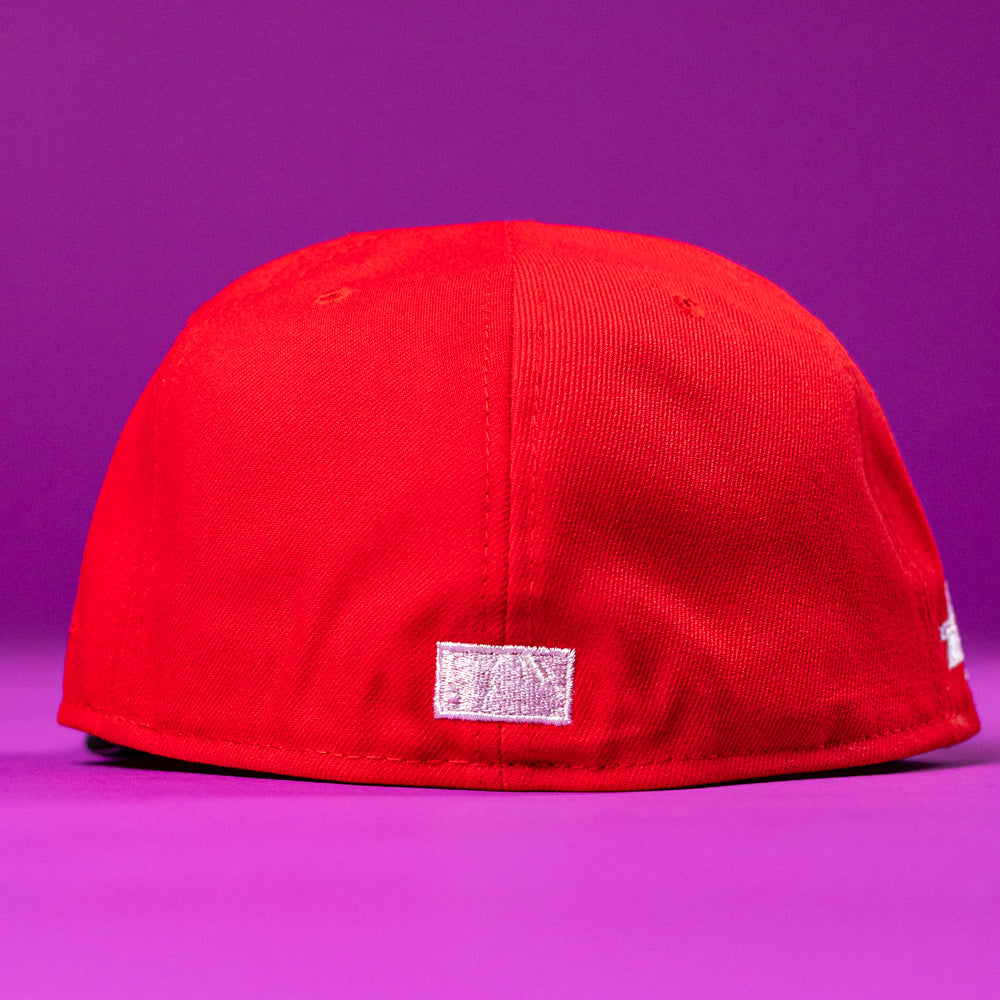 A Sabor Fresa New Era Red Houston Astros 5950 Fitted Hat is shown with the back facing the camera, set against a vibrant purple background.