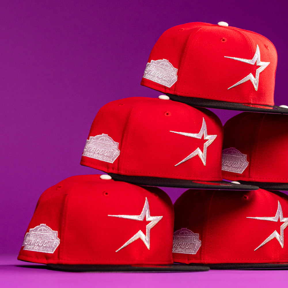 Five Sabor Fresa New Era Red Houston Astros 5950 fitted hats, featuring a large white star logo and silver side patch, are stacked in a pyramid against a purple background. #BuryMeInTheSouf.