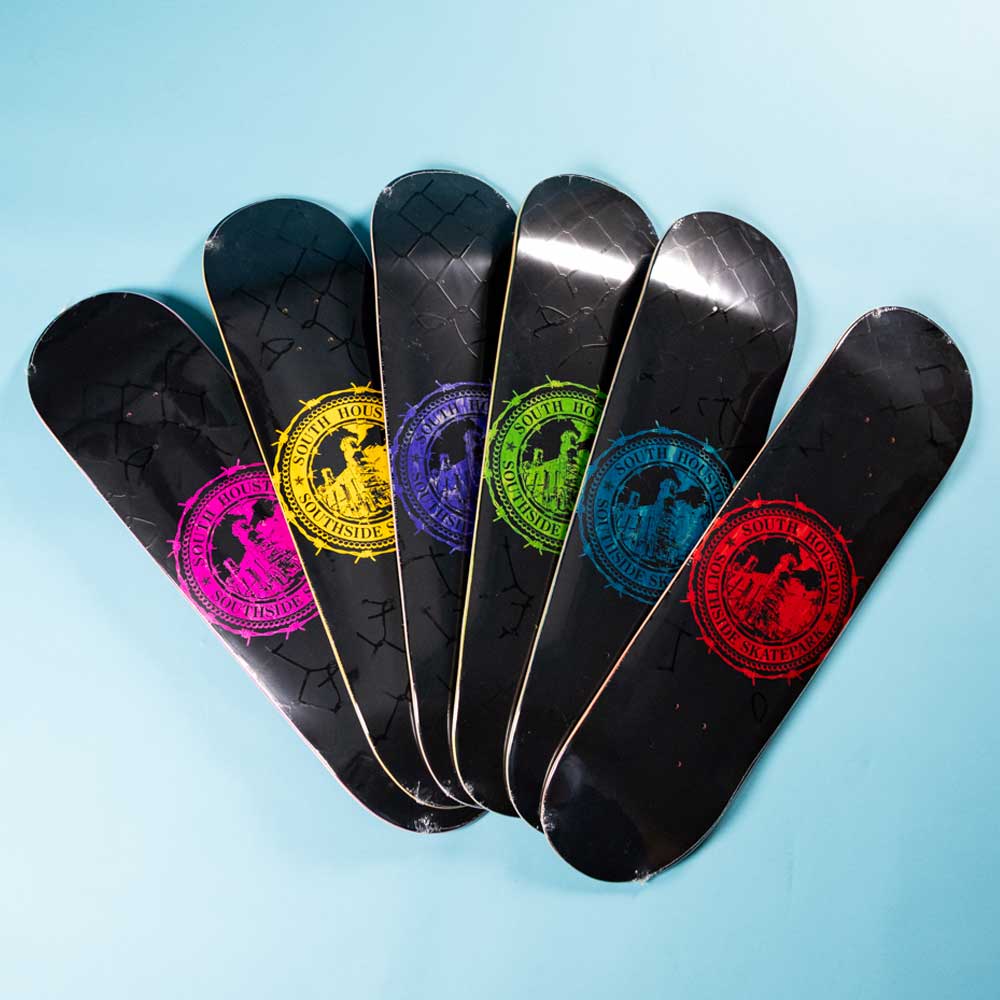 Six Refinery Southside Skateboard Decks by Bigo are arranged fan-like on a light blue surface, each with the same circular logo in a different bright color: pink, purple, yellow, green, blue, and red.