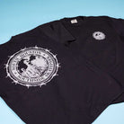 Two Refinery Southside T-Shirt Black Cool Gray Tees by Bigo feature a bold, industrial style with circular white Southside Skatepark logos on the back and chest, displayed on a light blue surface.