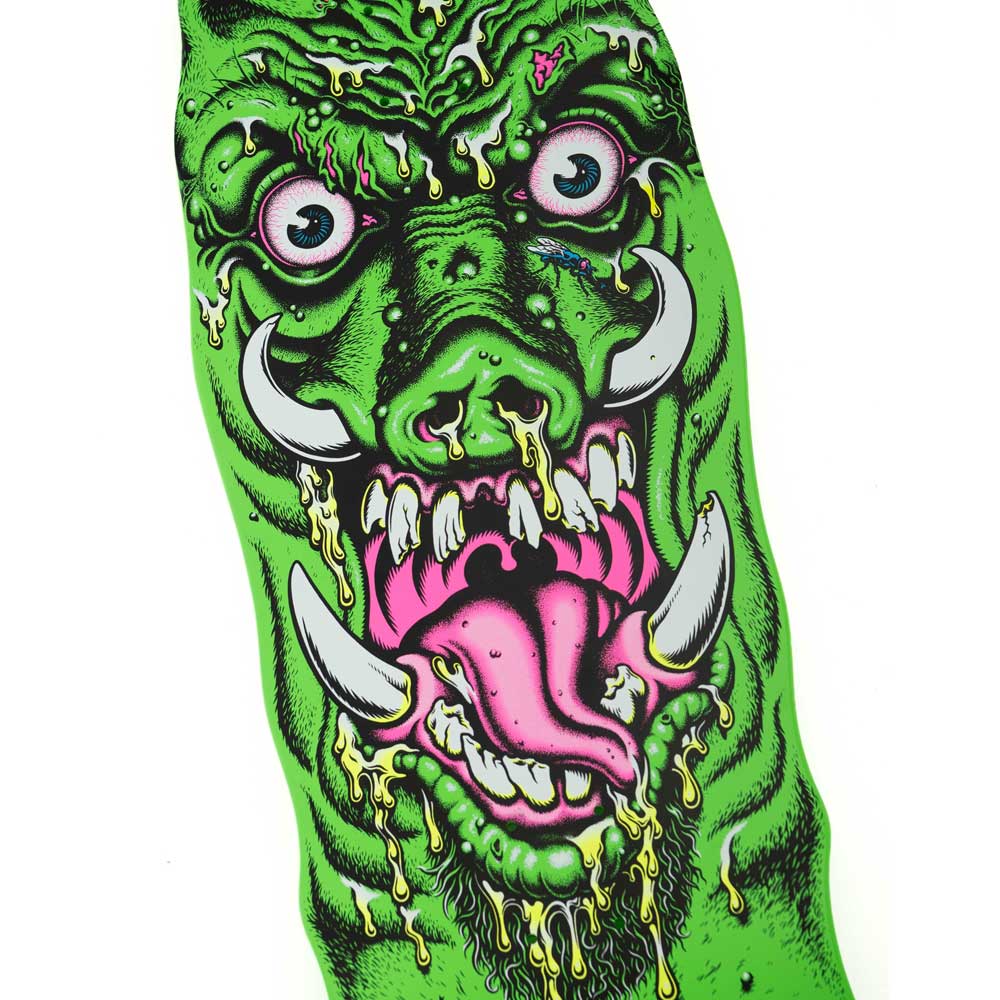 A vivid illustration of a green monster with tusks, bulging eyes, yellow drool, and a pink tongue sticking out is set against a white background—reminiscent of the bold graphics featured on the Roskopp Warthog Freaks 11.00in x 31.445in Santa Cruz Decks.