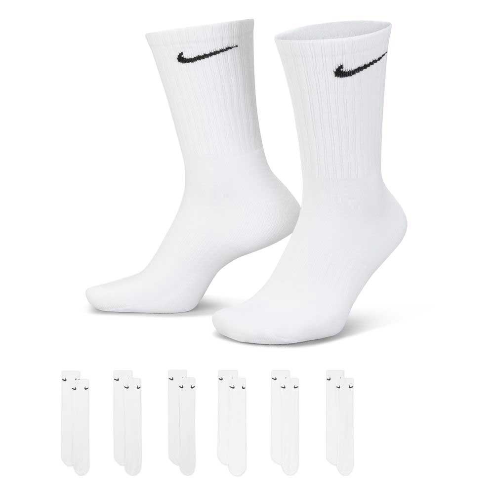 A six-pack of white Nike SB Crew Socks (style SX7666100) with black swoosh logos, featuring cushioned Dri-FIT technology; one pair is displayed on mannequin feet, with four extra identical pairs shown below.