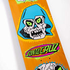 A close-up of the Scribble Head Feel Base 7.75in x 30.25in Santa Cruz Skateboards Deck shows a stylized skull with green eyes, a blue hood, and a colorful Santa Cruz logo on an orange background.