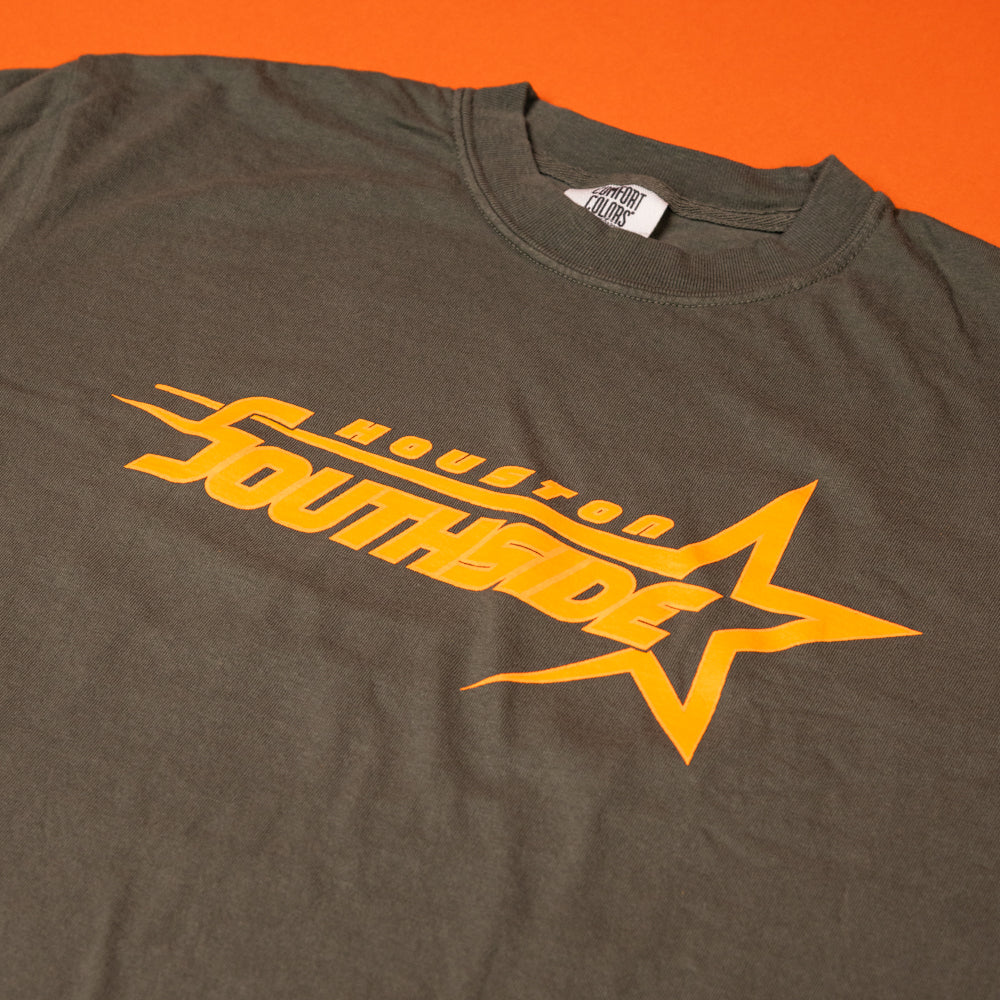 The Southside Sharp Star T-Shirt in moss green and tangerine features a yellow "Houston Southside" graphic with a stylized star—screenprinted for fans of retro skate culture, inspired by vintage tees from Southside Skatepark.
