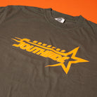 The Southside Sharp Star T-Shirt in moss green and tangerine features a yellow "Houston Southside" graphic with a stylized star—screenprinted for fans of retro skate culture, inspired by vintage tees from Southside Skatepark.