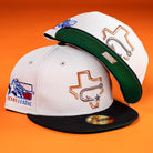 The Backlash Corpus Christi Hooks New Era 5950 Fitted hat is a white cap with a black brim, featuring embroidered Texas-themed logos and patches like the Texas outline and League emblem on an orange background.