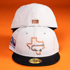 Two light gray Backlash Corpus Christi Hooks New Era 5950 fitted hats with black brims are shown on an orange background. The front displays a Texas outline with fish hook; the back features a small MLB logo.