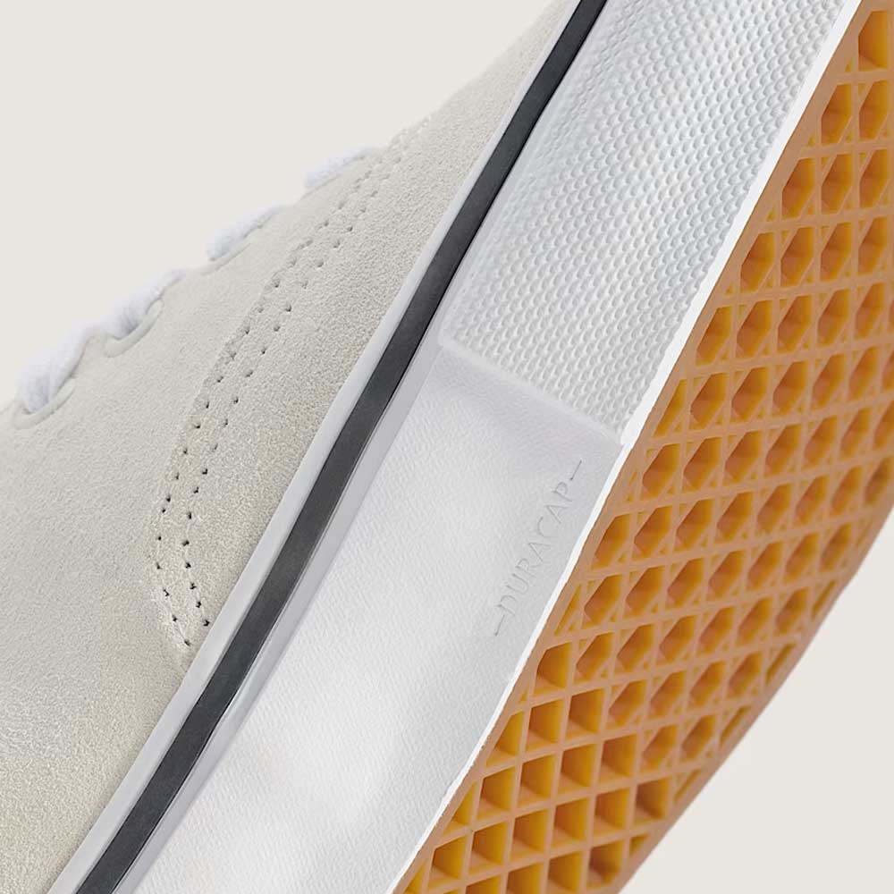 Close-up of the Skate Authentic White Gunmetal Vans VNOA5FC8XQL white suede skateboarding shoe featuring a textured gum rubber sole for traction, a black pinstripe above the sole, and “DURACAP” embossed on the midsole.
