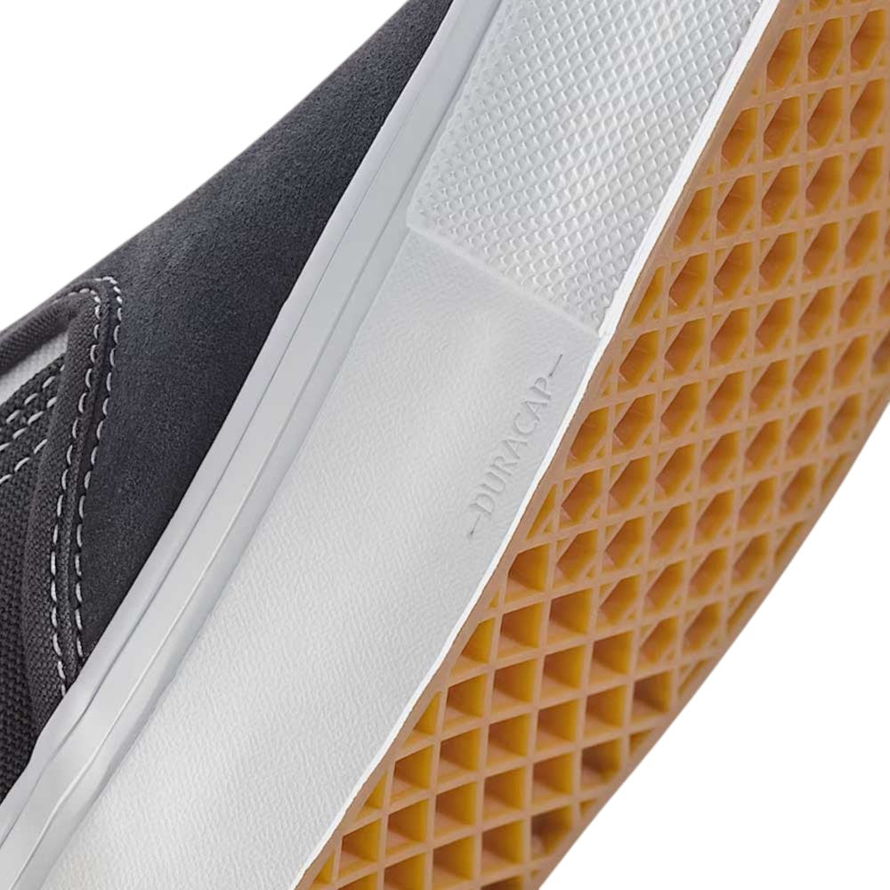 Close-up of the gum rubber waffle sole and white midsole of the Vans Skate Slip On Pewter True White VN0A5FCA1N6 suede shoe, featuring visible stitching and DURACAP embossed on the side, showcasing enhanced durability for impact protection.