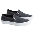 A pair of Vans Skate Slip On Pewter True White VN0A5FCA1N6 suede shoes, featuring a dark gray upper with white soles and visible white stitching, are positioned side by side against a plain background. These slip-ons are designed for enhanced durability and impact protection.
