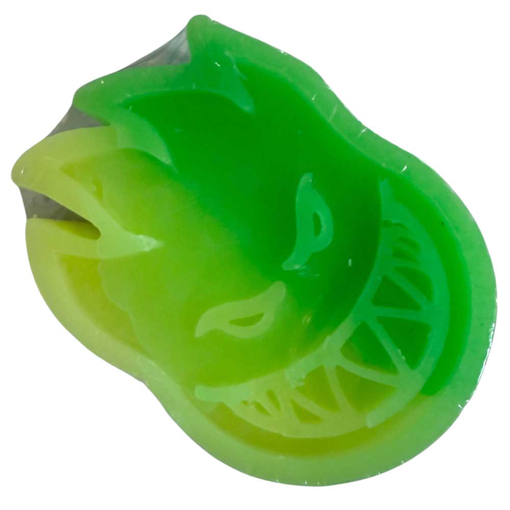 The Skateboarding Swirl Curb Wax Spitfire Wheels Swirl Green Yellow features a green and yellow flame design with a mischievous grin—an eye-catching addition to any setup or as unique curb wax.