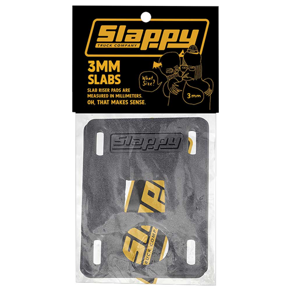 A pair of Slappy Slabs 3mm Black Low Risers for skateboards, with black rectangular pads, slotted holes, yellow branding, and packaged in clear plastic with a branded black-and-yellow header.