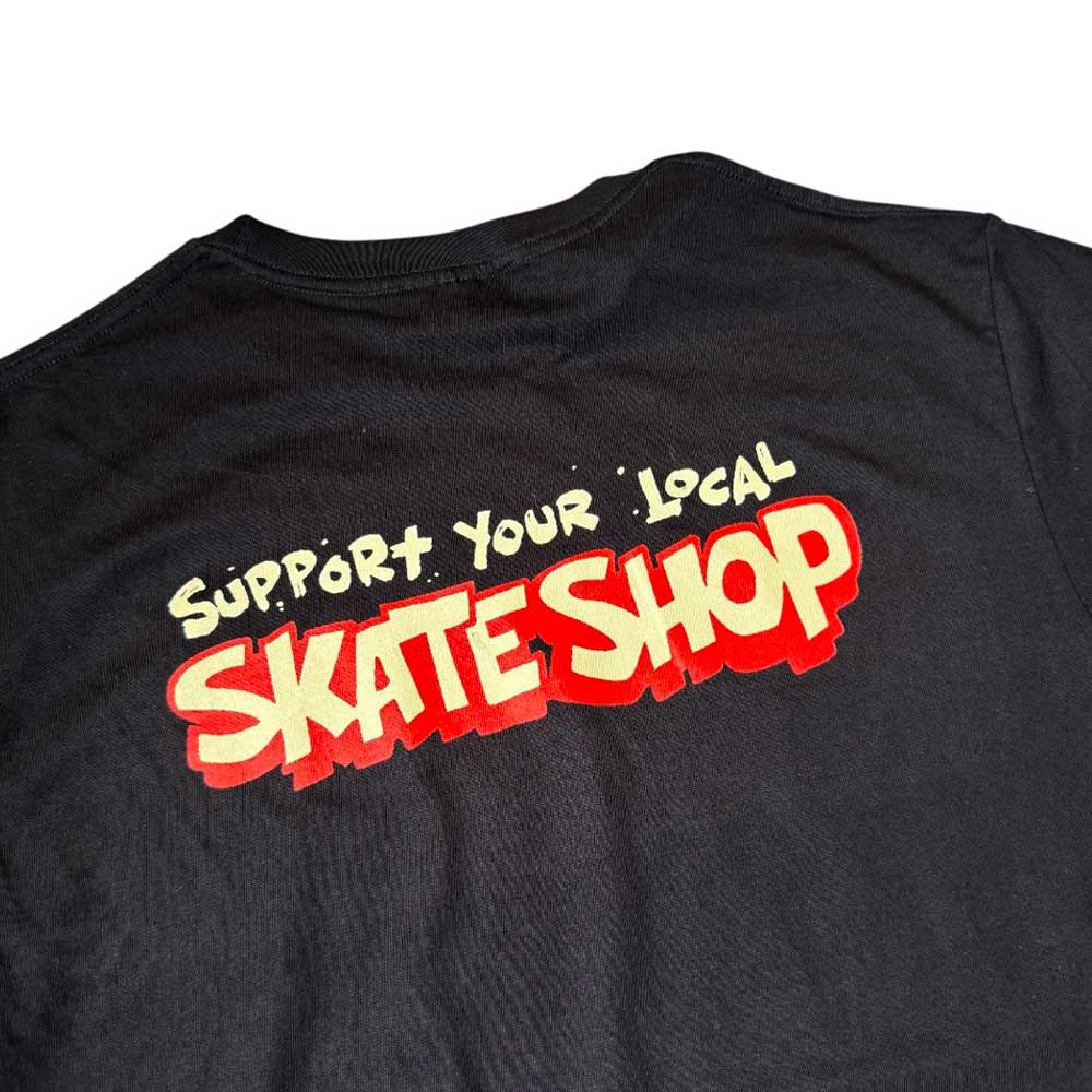 The Southside Support Your Local Skateshop Black Tee Skateshop Day features Brett Parson artwork and "Support Your Local Skate Shop" in bold yellow and red graffiti-style print on the back.