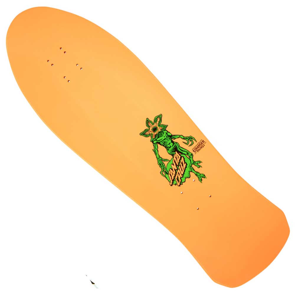 The Stranger Things Salba Demogorgon 10.3in x 31.1in Santa Cruz Skateboard Deck features an orange shape with a green cartoon lizard holding a staff on a yellow logo, plus wide, rounded nose and squared-off tail for unique style and control.