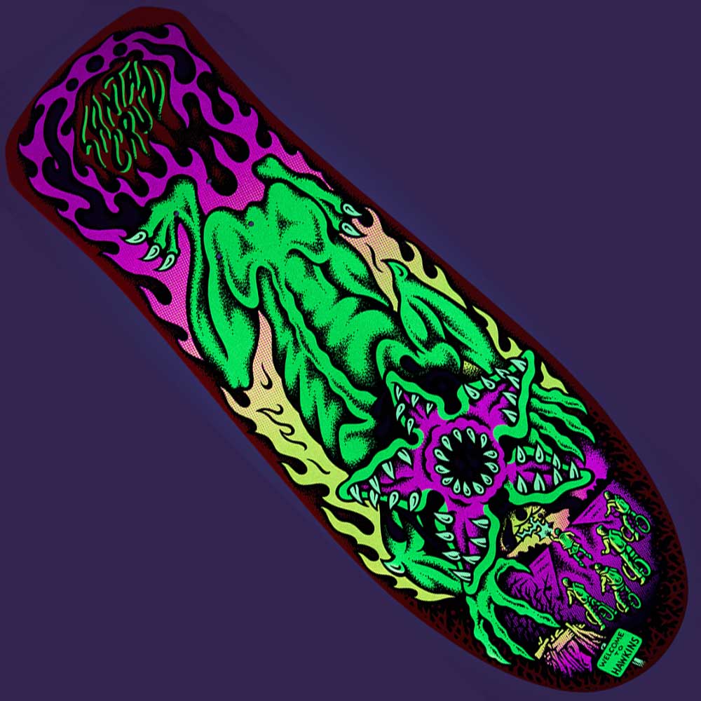 The Stranger Things Salba Demogorgon 10.3in x 31.1in Santa Cruz Skateboard Deck features vivid neon art of a green monster with sharp teeth, purple and black flames, small green figures, and a deep purple background.