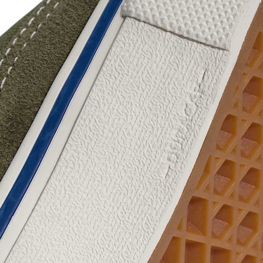 Close-up of Suede Canvas Mossy Olive Authentic VN0A5FC8FR11 Vans Skate Shoes featuring a green suede upper, white midsole with blue stripe, gum waffle outsole, white stitching, rubber toe cap, and PopCush footbeds for comfort in vulcanized skateboarding.