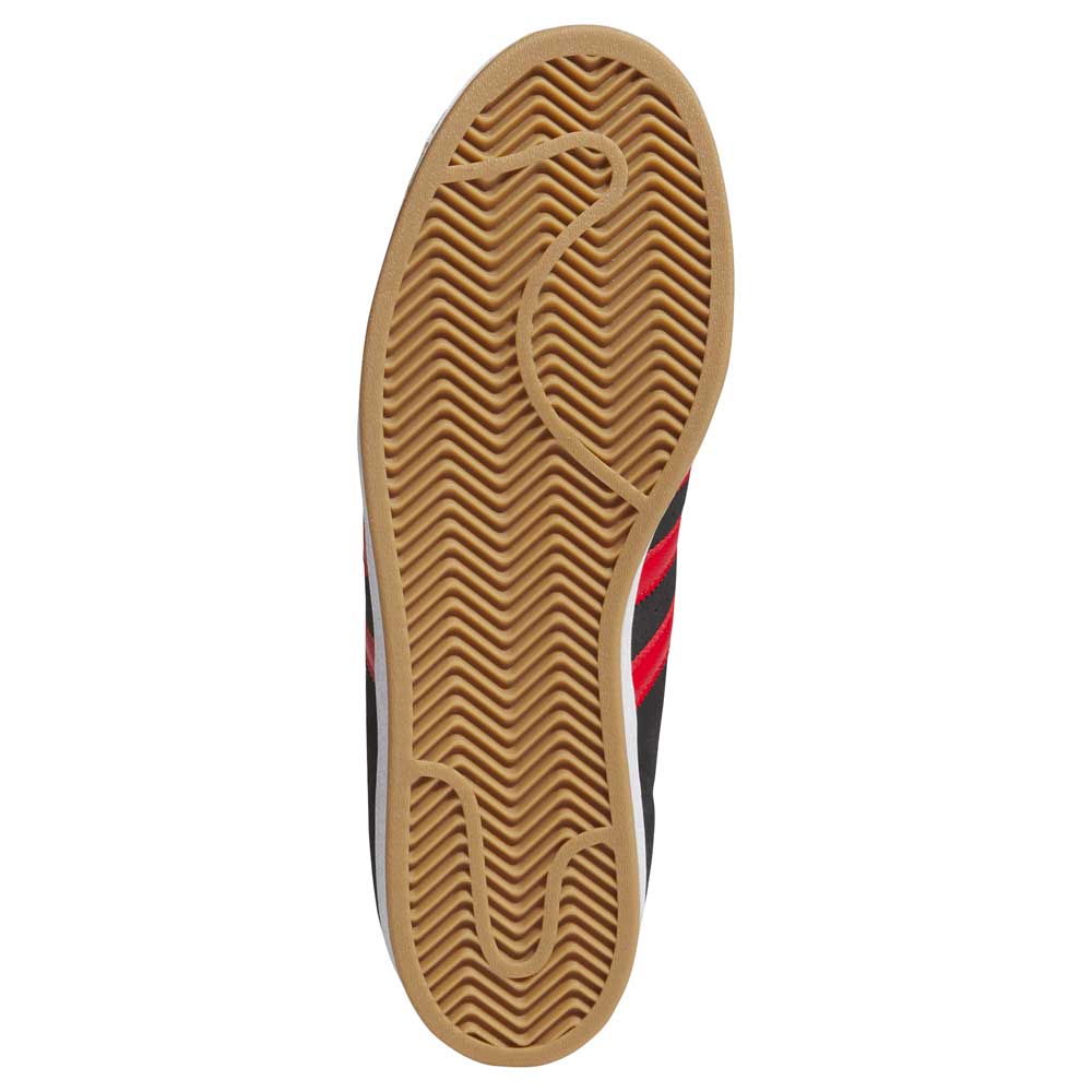 The image shows the brown rubber sole with herringbone grip of the adidas Superstar ADV Black Red KI5731 Suede Leather Skateboarding Shoes. The upper, partially visible, features black and red accents typical of adidas Originals.
