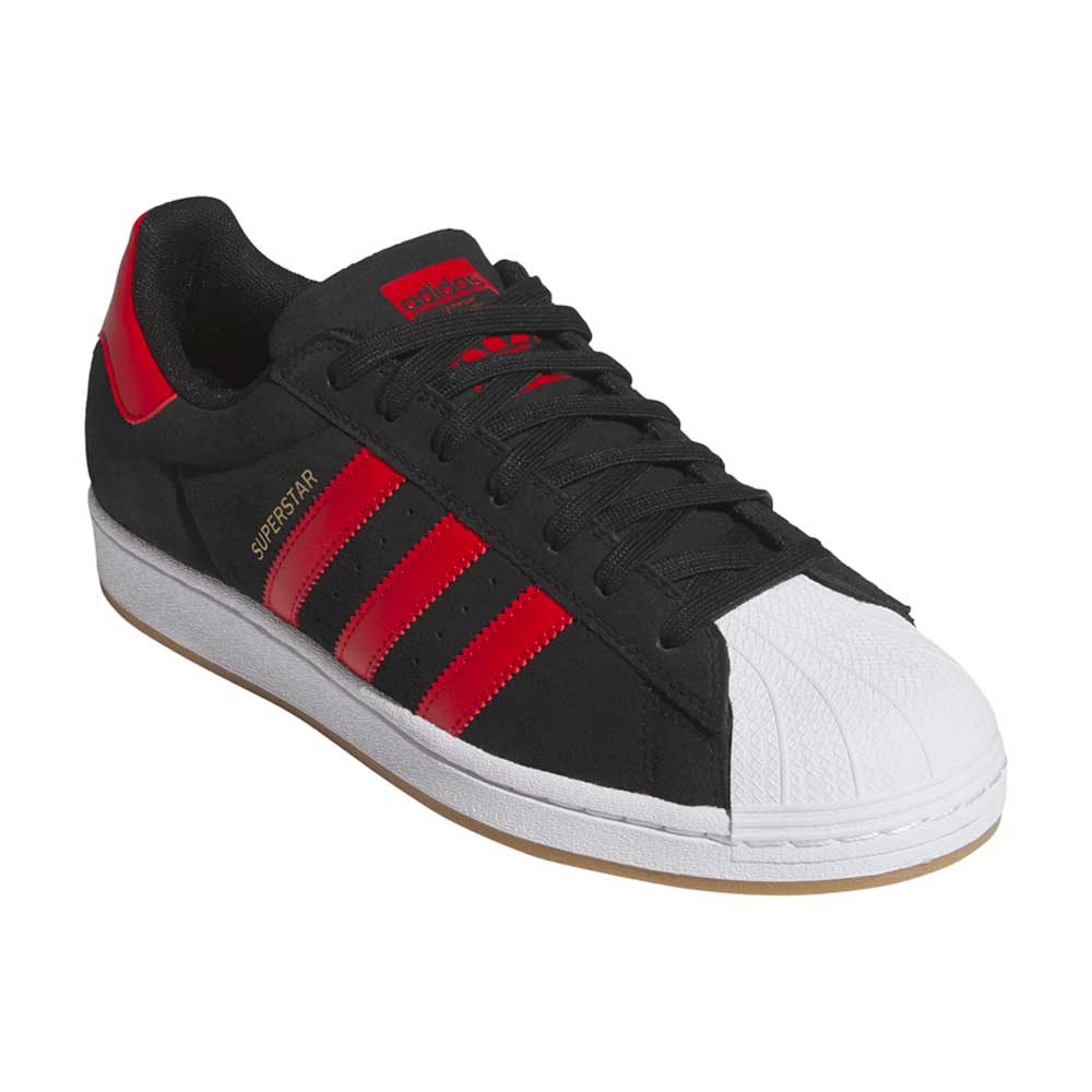 The Superstar ADV Black Red KI5731 by Adidas Skateboarding features black suede leather, red stripes and heel tab, black laces, a white rubber shell toe, a white sole, and gum bottom.