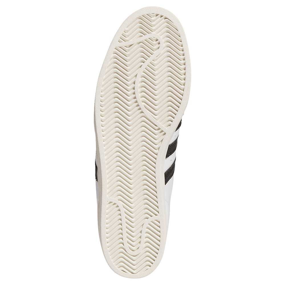 The image shows the sole of the Superstar ADV White Black KI5727 adidas Skateboarding Shoe with a herringbone tread, designed for skateboarding. The clean white sole reveals part of the black adidas Originals stripes near the edge.