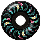 The Team Floral Black 54mm99A Formula Four Spitfire Wheels Classic feature a black wheel with a circular pattern of green leaves and pink, white, and yellow tropical flowers.