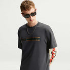 Charcoal gray short-sleeved Tee Black IW3134060 T-Shirt Nike SB Skateboarding with a horizontal chest graphic, worn over a long-sleeved shirt with red and white printed text on the sleeve.