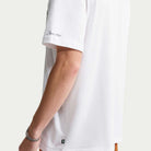 A person wearing a white Tee White IW3134100 T-Shirt Nike SB Skateboarding featuring the text Depuis 2002 on the sleeve and a small logo patch at the bottom hem.