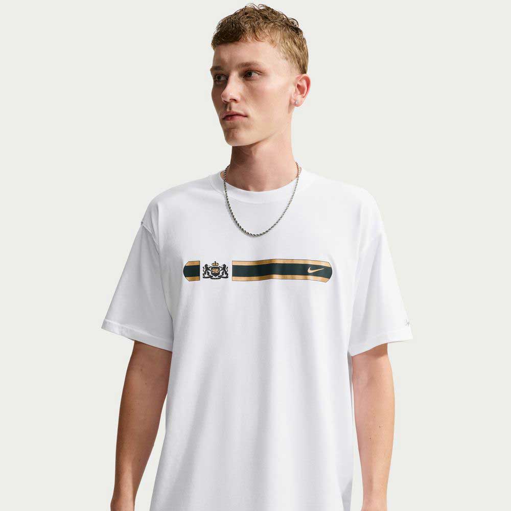 A man wearing a white Tee White IW3134100 T-Shirt Nike SB Skateboarding featuring a horizontal black and gold band across the chest with a crest and a small logo.