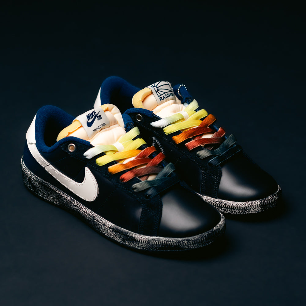 A pair of blue Zoom Tennis Classic x Rassvet IO9846400 Nike SB leather skateboarding shoes featuring white accents and comfortable insoles, displayed on a dark surface.