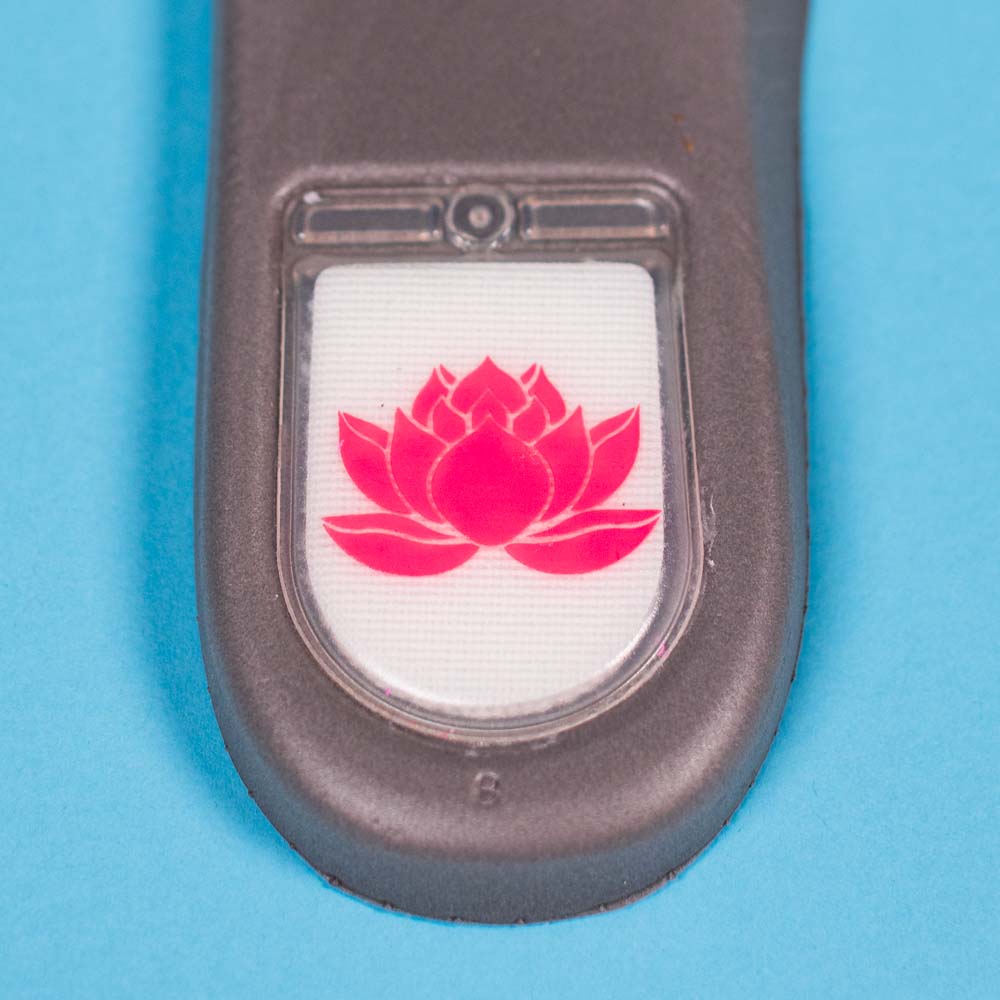 A close-up of a gray device with a white rectangle showing a red lotus flower on a light blue background—ideal for fans of the READ BELOW the BUTTON RAFFLE Nike SB Som Tum Dunk Low at Southside Skatepark Skateshop.
