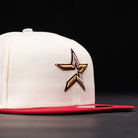 The Final Hour New Era Hat 5950 Fitted NEW YEAR DROP is a white cap with a red brim, featuring a large embroidered star logo in gold, brown, and white on the side. Its black background highlights the vibrant details. Available at Whatafitted.