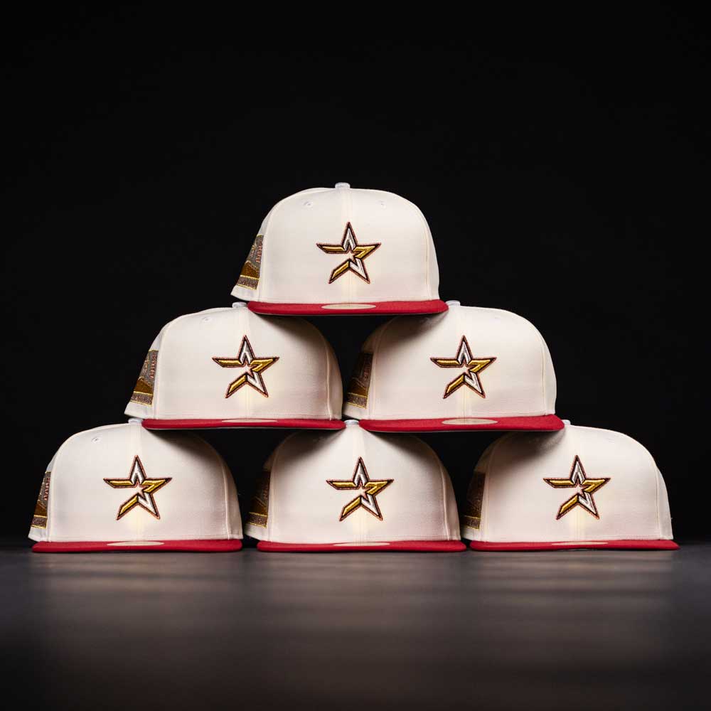 Six white The Final Hour New Era Hat 5950 Fitted NEW YEAR DROP caps with red brims and gold star logos are stacked in a pyramid against a black background, highlighting their bold style.