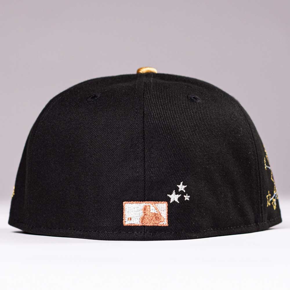 The Last Call New Era Hat 5950 Fitted NEW YEAR DROP seen from the back, black with small white embroidered stars and an orange-and-white rectangular patch near the bottom edge—a standout design.